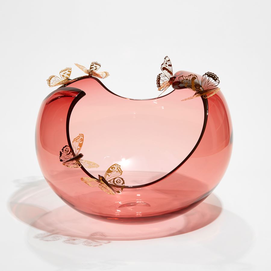soft peach bubble bowl with meandering cut edge with six gold butterflies peached around on the rim hand made from blown glass and steel