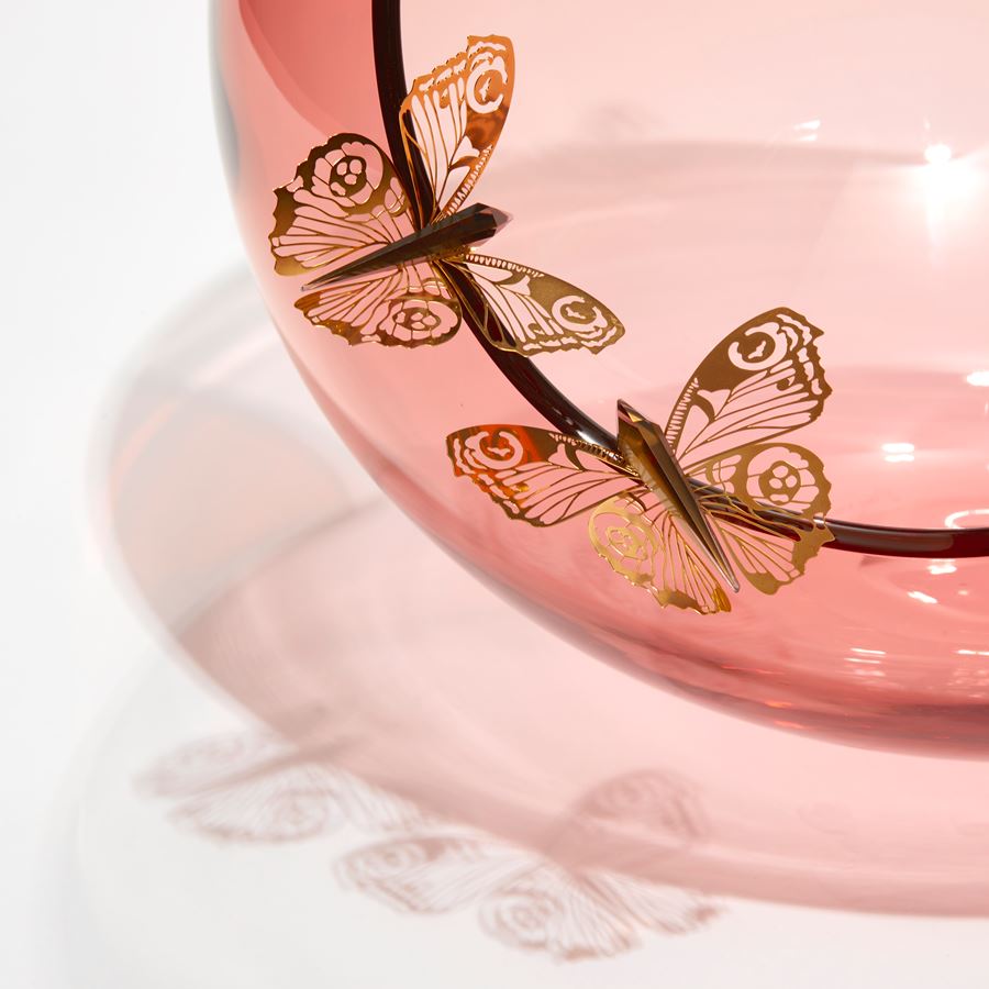 soft peach bubble bowl with meandering cut edge with six gold butterflies peached around on the rim hand made from blown glass and steel