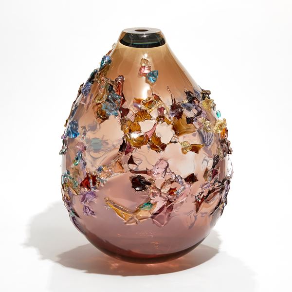 pink fading to brown rounded teardrop vessel covered in multicoloured organic shards made from blown glass