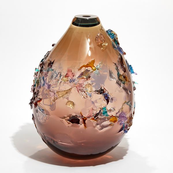 pink fading to brown rounded teardrop vessel covered in multicoloured organic shards made from blown glass