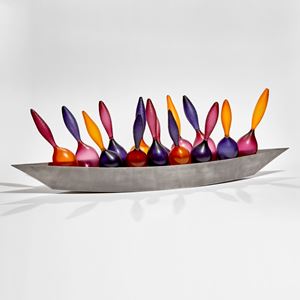 rich purple raspberry and orange glass amphora shaped bottles cradled in a steel boat shaped hull 