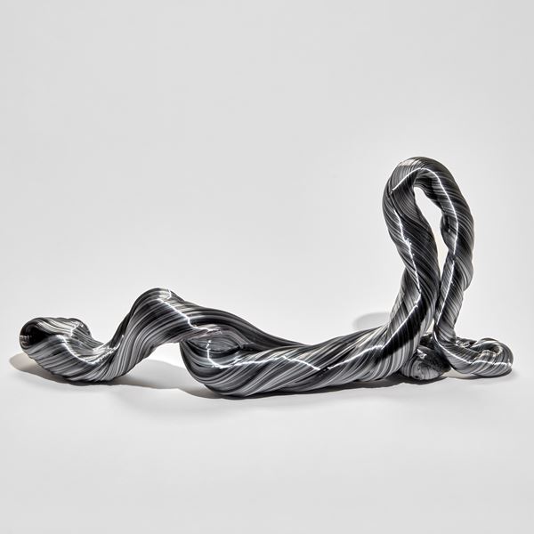 grey twisted and looping ridged sculpture mimicking an unravelling piece of wool hand made from glass