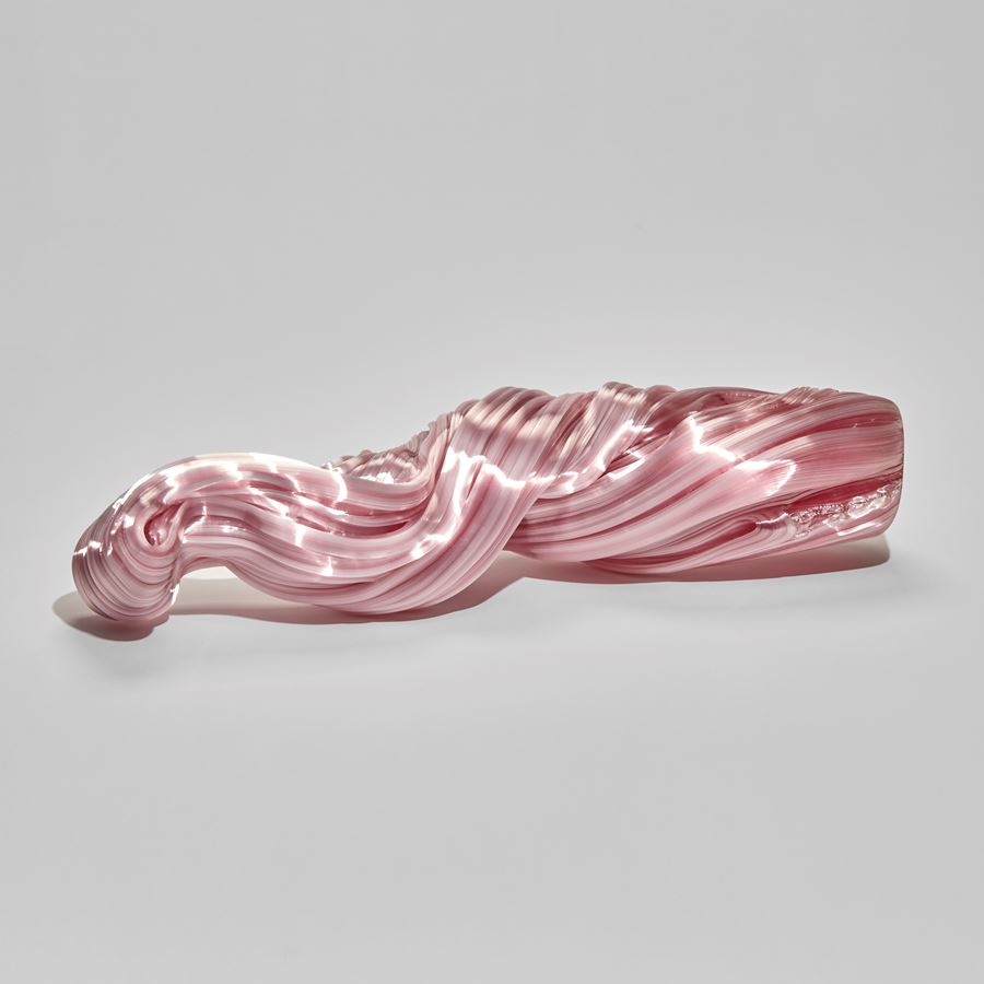 ridged and undulating pink twisted long glass sculpture with the appearance as if made from pulled and stretched sugar cane