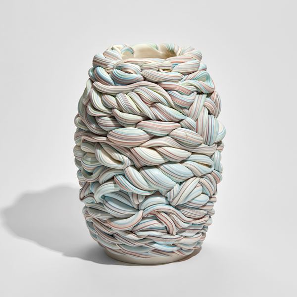white blue and pink barrel shaped vessel that looks like a bobbin of wool hand made from parian porcelain