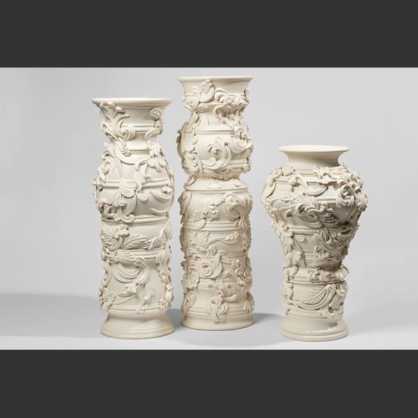 undulating column vase handmade from porcelain covered in organic flourishes and abstract leaves with rounded opening at the top