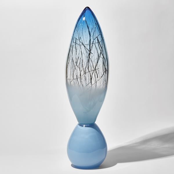 pale baby blue and aquamarine tall glass sculpture with rounded base and pointed oval top with thin white and silver glass canes trapped inside