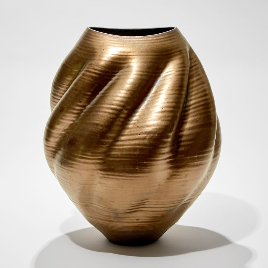 gold shell like vessel with twisting form and spiralling ridges hand made from glass