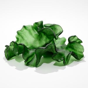 rich green sculpture resembling a piece of curling and frilled seaweed with soft matt surface one side with the other with ridged texture hand made from cast glass