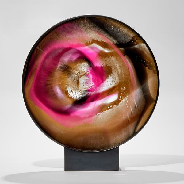rounded 2d sculpture in metal frame and base made from shattered glass with trapped colours in gold black and bridge pink hand made