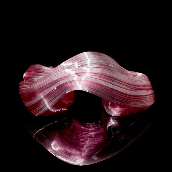 pink arched and bending ridged candy cane sculpture hand made from glass