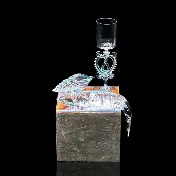 three dimensional still life with goblet shell and fish sitting on a grey concrete effect plinth handmade from glass