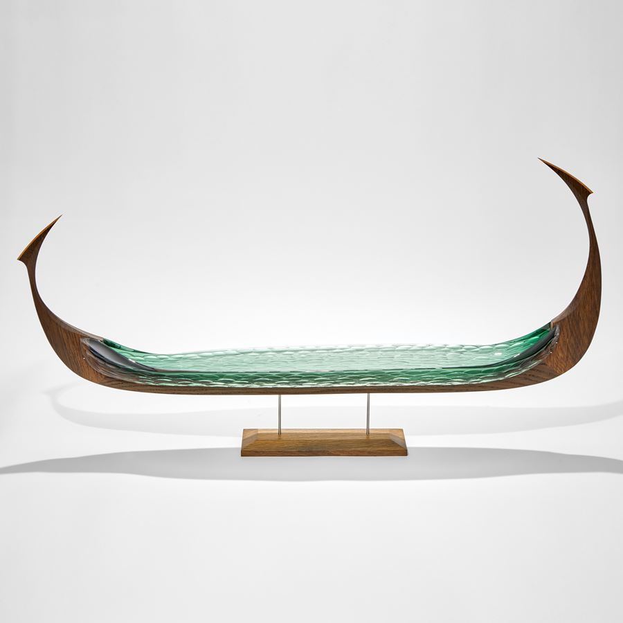 long viking ship with oak hull and soft green blown and cut hull handmade and raised on a stand