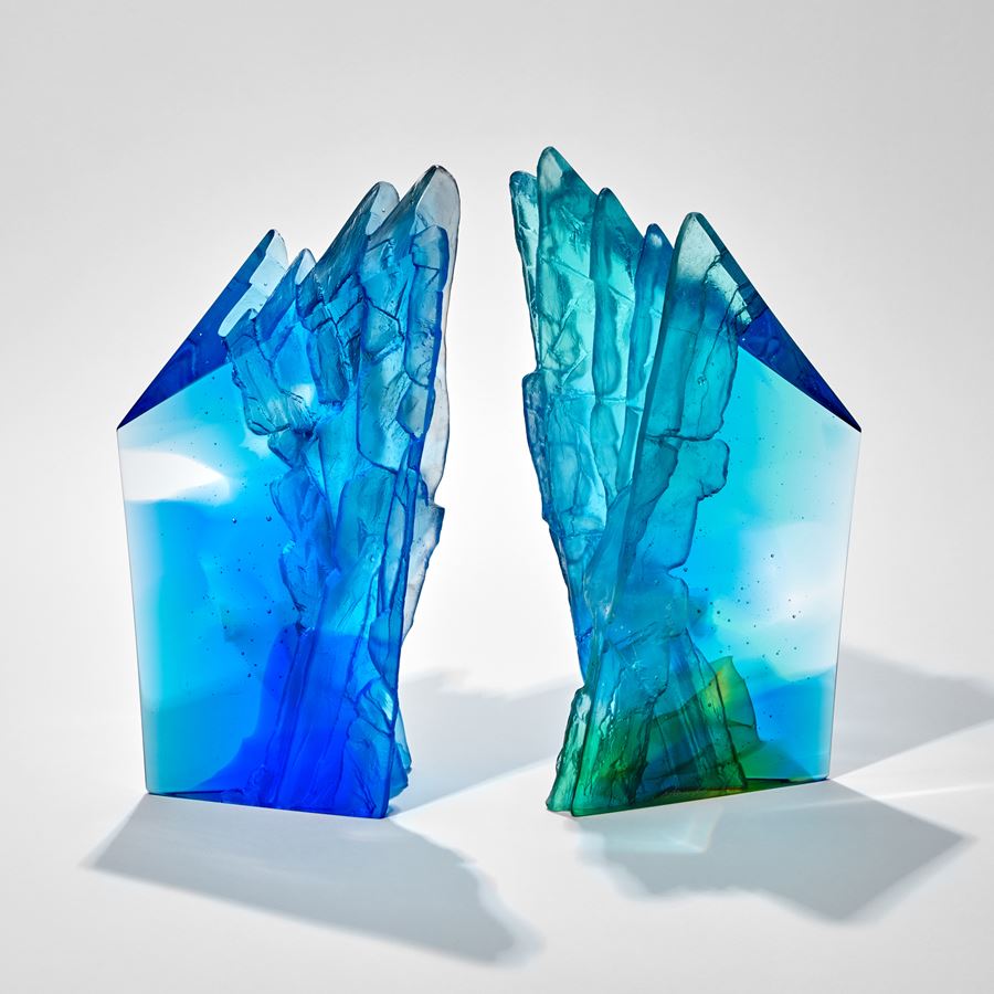 asymmetric mixed blues standing sculpture emulating a cliff face with two sides smooth and one ridged and textured hand made from glass
