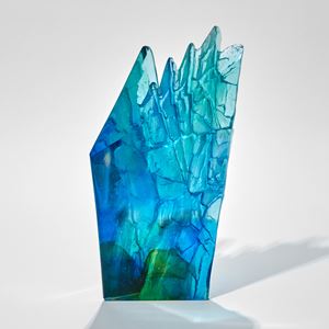 green aqua and blue cliff inspired artwork with two smooth surfaces with one that is craggy rough and textured hand made from glass