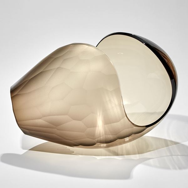 bronze transparent shell like sculpture with one side covered in facets hand made from glass