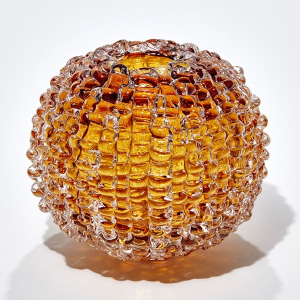 urchin inspired amber gold round sculpture with undulating surface handmade from glass