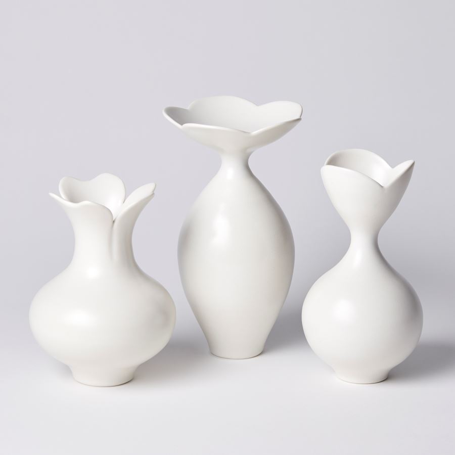 white classically shaped vase with flower shaped opening with three petals hand made from porcelain