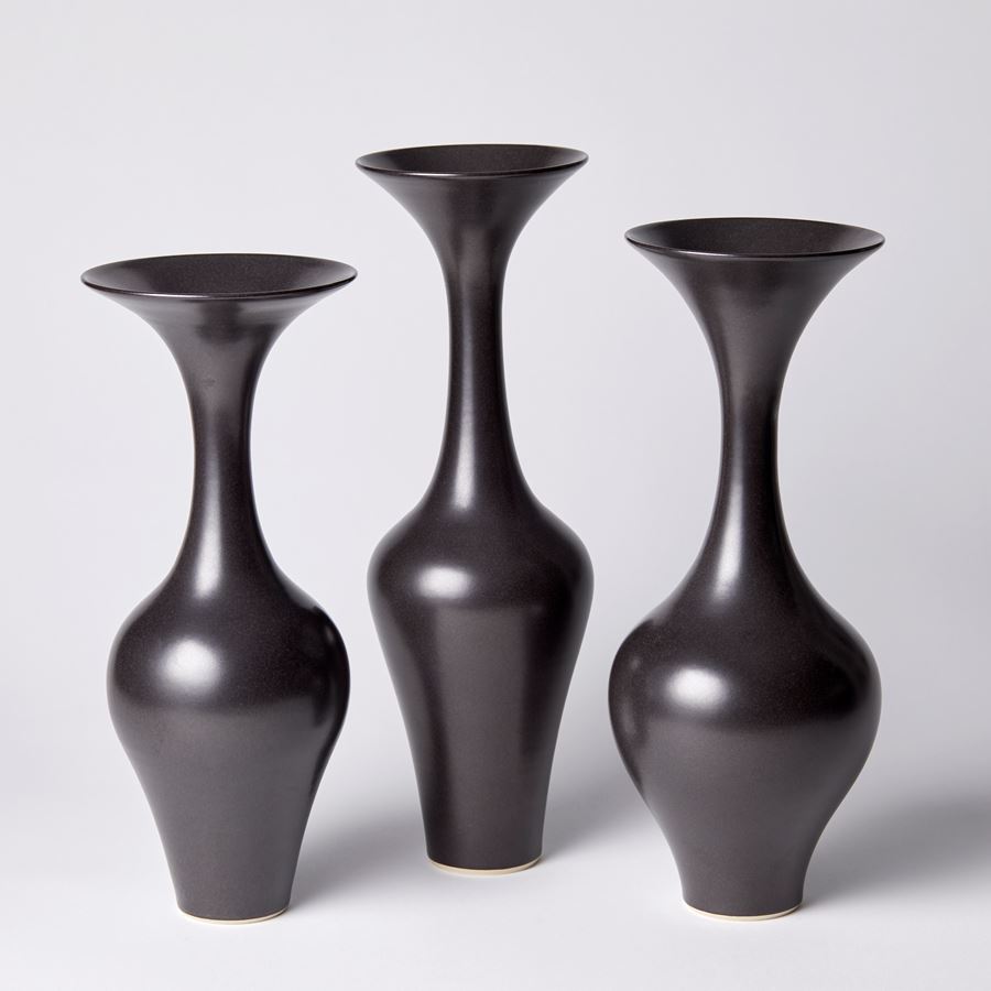 black classic in shape vase with round base long slim neck and trumpet flaring rim hand thrown from porcelain and glazed