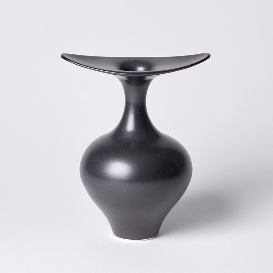 classically shaped base black vase with finned flared opening spanning in two directions hand made from porcelain