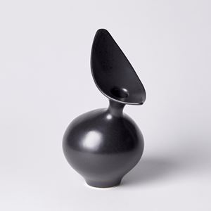 black round vase with off centre neck and offset stretched oval finned opening hand made from porcelain