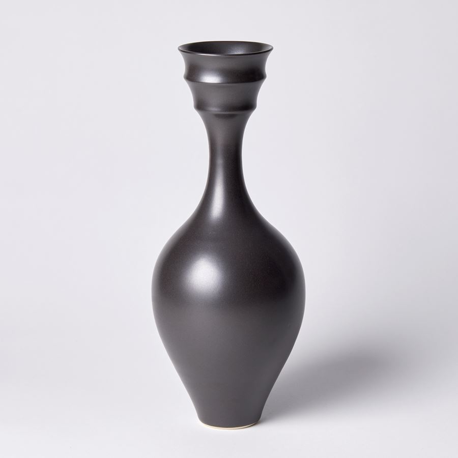 black rounded bodied vase with tall slender neck and double rimmed opening hand made from porcelain