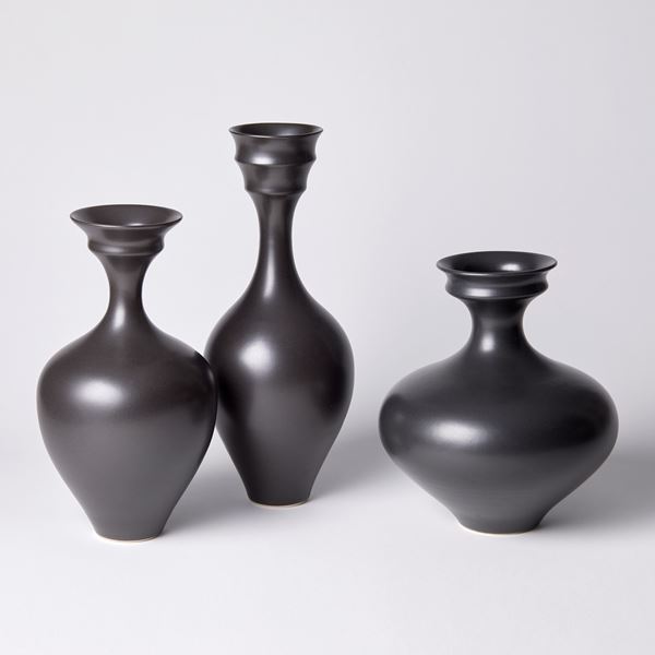 black rounded bodied vase with tall slender neck and double rimmed opening hand made from porcelain