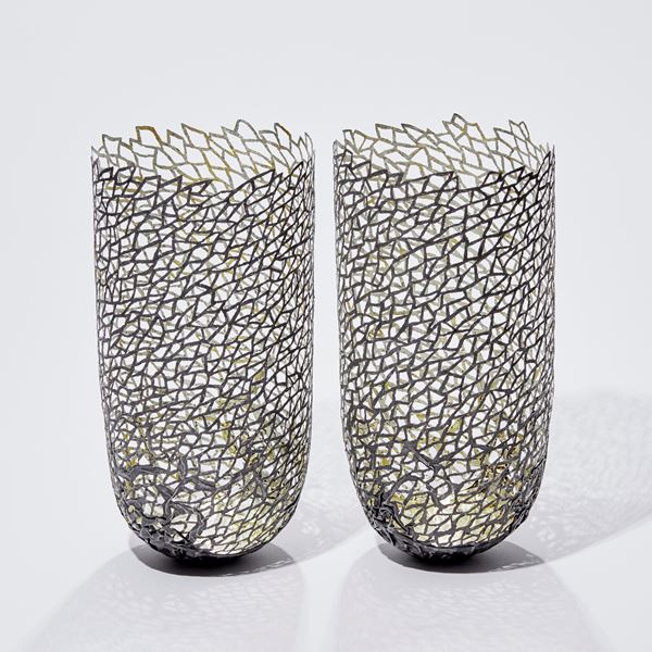 two modern art sculpted vessels made from steel and gold 