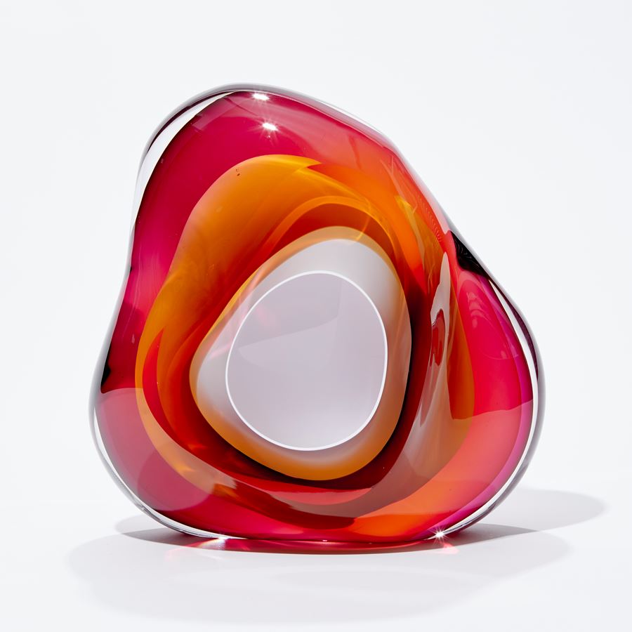 amorphic abstract form consisting of merging pink and amber covering an inner of crisp white handmade from glass with central cavity