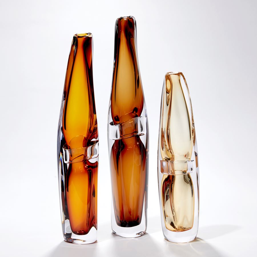 tall slender and organic in form transparent amber vase with clear middle band hand blown from glass