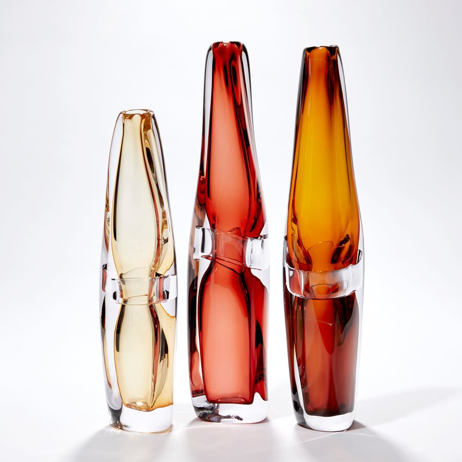 clear and transparent amber tall vase with fluid lines and soft narrowing top handblown from glass