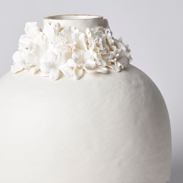 rounded jar with slightly uneven surface and floral ring around the opening with gold lustre band hand made from porcelain and parian