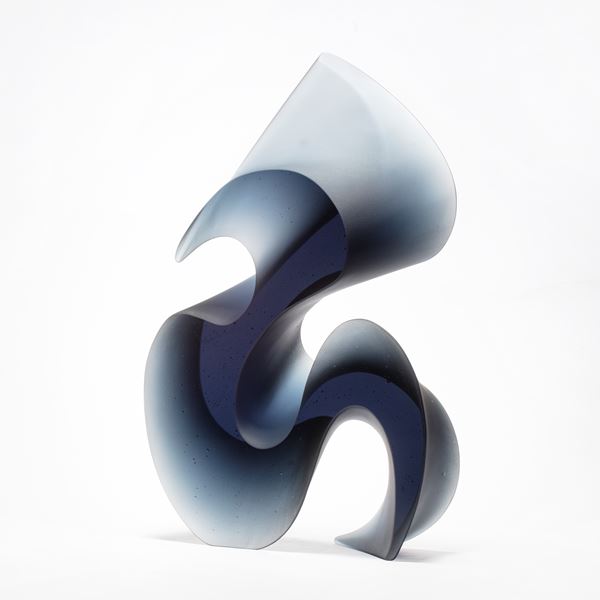 greyish blue tall curved and curling abstract shape made from cast glass with two flat polished sides and curved matt satin sides