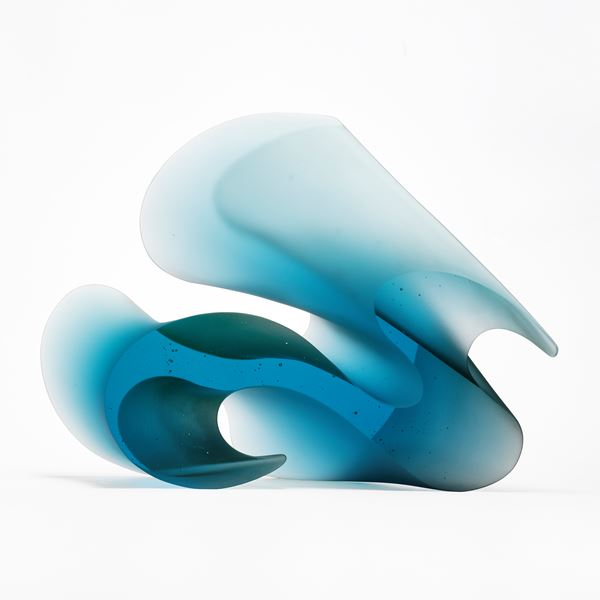 aqua blue curved standing abstract sculpture with two flat shiny parallel sides with the opposed sides curved and matt