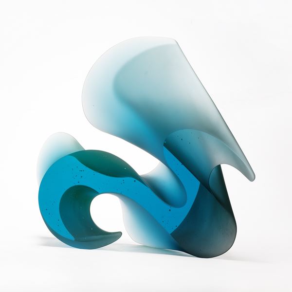 aqua blue curved standing abstract sculpture with two flat shiny parallel sides with the opposed sides curved and matt