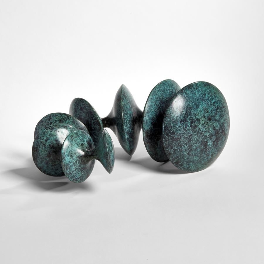 sculpted bronze artwork of circular forms linked by thread