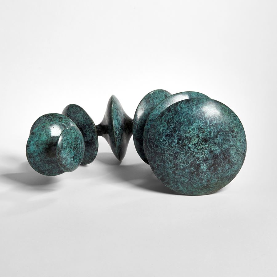 sculpted bronze artwork of circular forms linked by thread