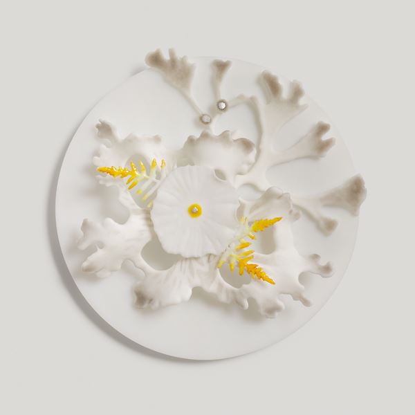 white round disc with white grey and yellow organic feathered and plant inspired raised organic detail handmade from glass
