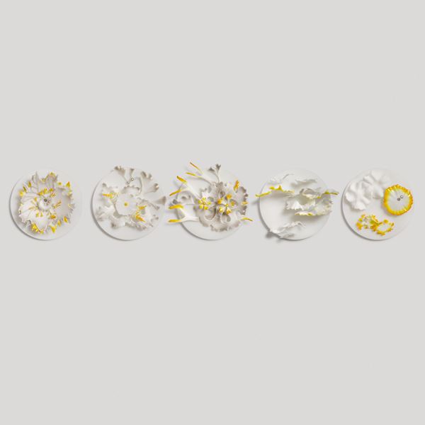 white disc with organic frilled floral raised detail in white amber yellow and silver handmade from glass