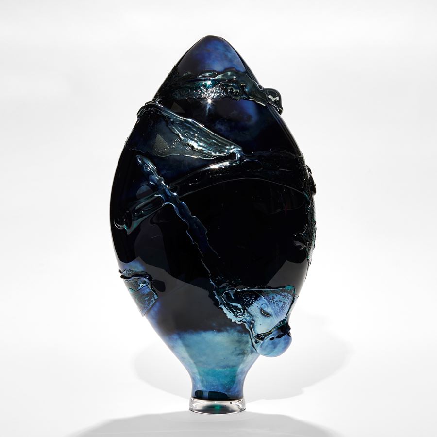 dark intense metallic blue teardrop shaped vase with organic trailing and swirling raised texture hand made from glass
