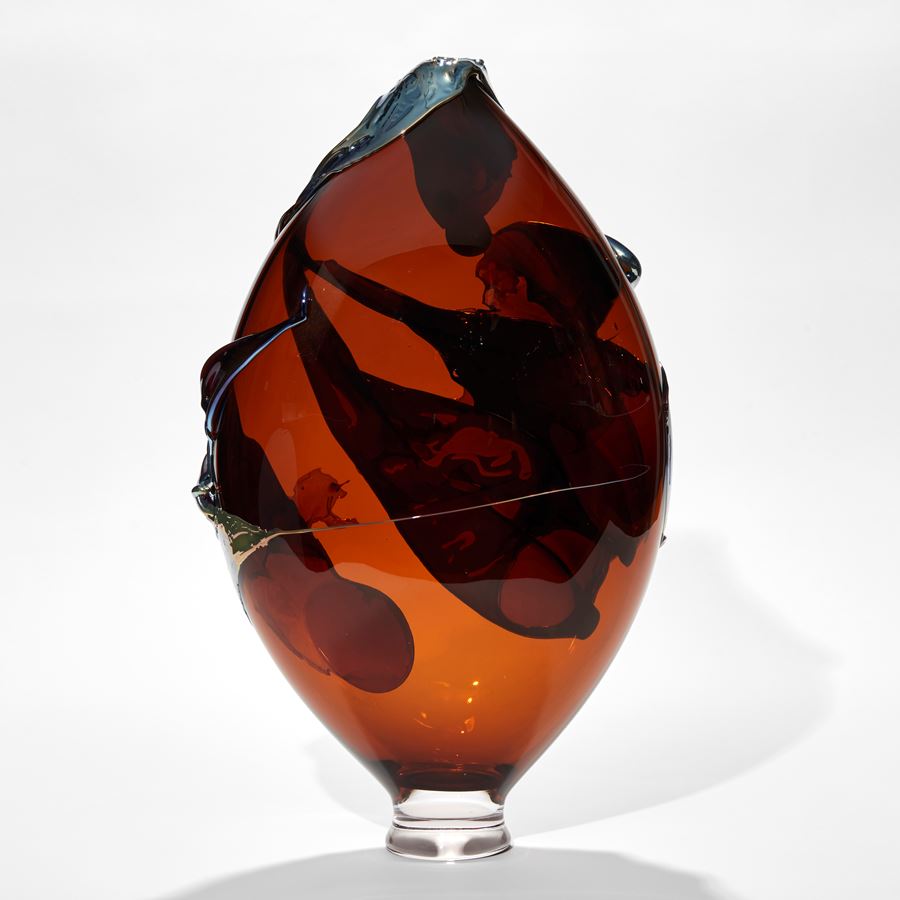 dark amber teardrop vase with metallic blue trails and raised organic detail handmade from glass