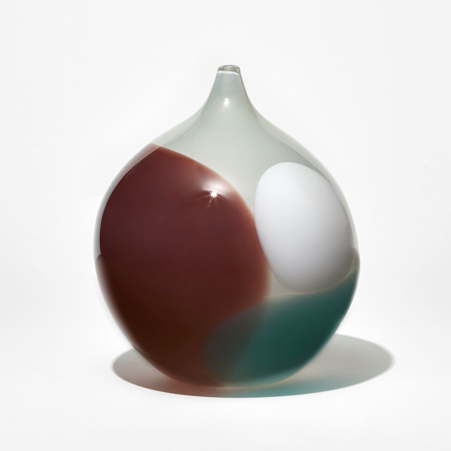 opaque white round vase with elegant narrow pointed neck with abstract spots in rich brown white and teal aqua hand made from glass