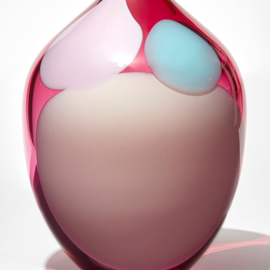 transparent rich ruby pink rounded jar with narrow neck with small opening with abstract amorphous blobs in opaque baby pink blue and soft pink hand made from glass