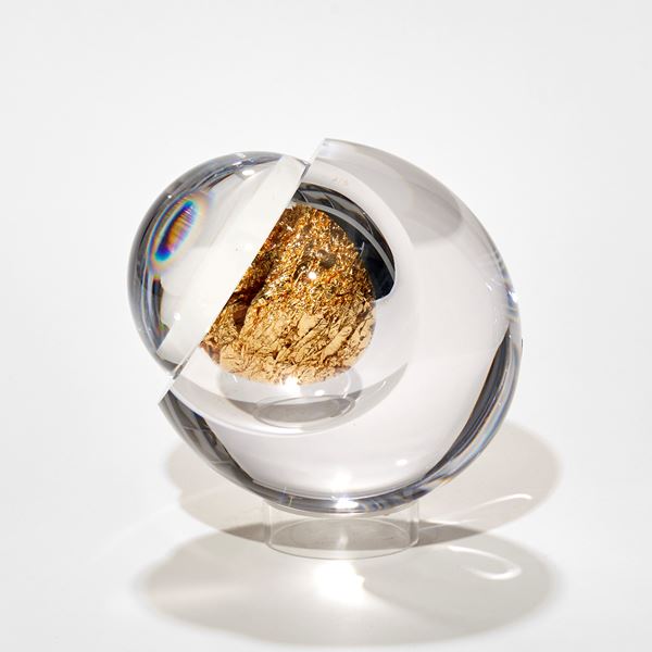 clear round ball with interior filled with gold with lens lid enhancing the contents handmade from glass