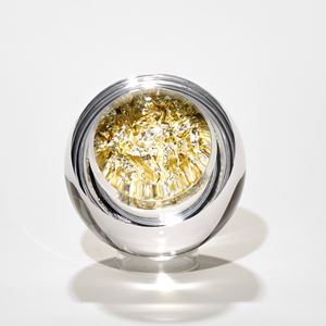 clear round glass mass with interior filled with pale gold leaf crushed to fill the void with lens lid magnifying the contents hand made