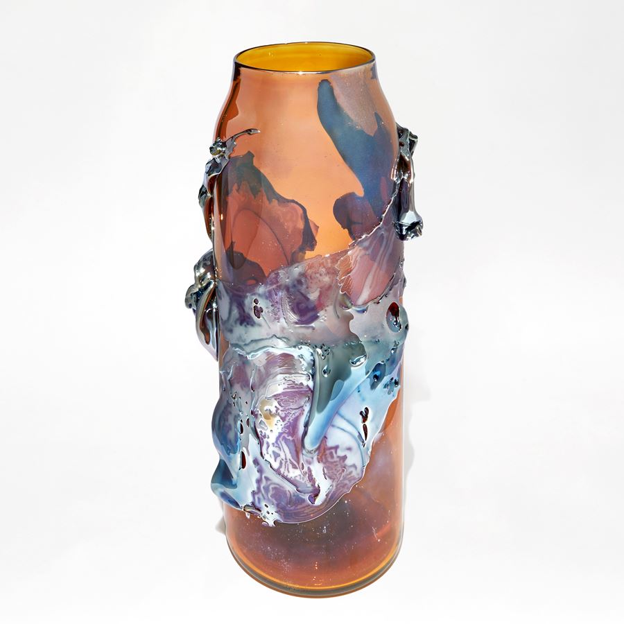 brilliant transparent amber cylindrical vase with tapering neck with roushed organic textural raised detail in metallic blue and lilac handmade from glass