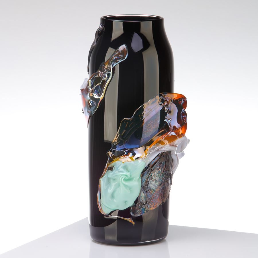rick black brown transparent cylindrical vase with tapering neck with central organic raised band in iridescent lilac amber blue and jade mimicking a roushed band of silk fabric handmade from glass