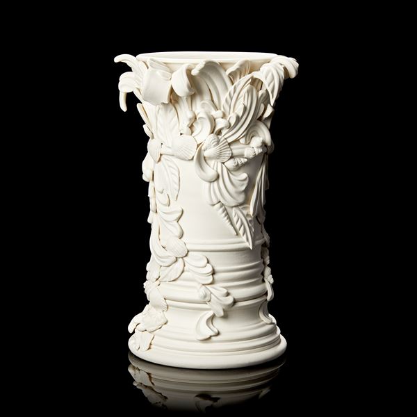 light cream column shaped vase with flared base and top covered in baroque swirls and shells hand made from porcelain
