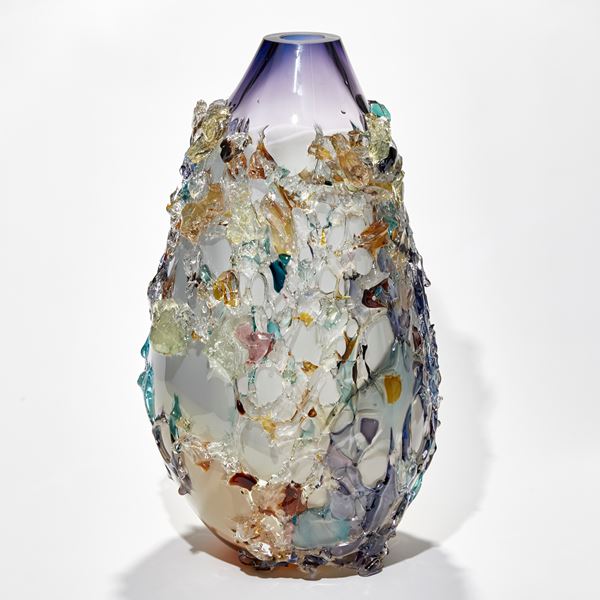 elongated organic teardrop shaped vessel in light apricot white and rich purple with exterior patchy texture in differing colours handmade from glass