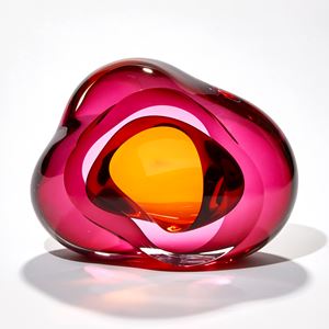 intense transparent pink with an amber gold centre amorphous sculpture with fluid lines and central opening with inner cavity hand made from glass