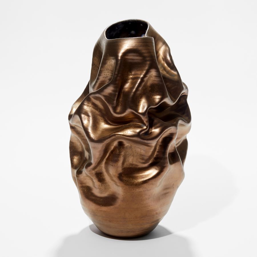 ceramic tall stain gold ridged and wrinkled vessel with crumpled surface hand made and thrown from clay